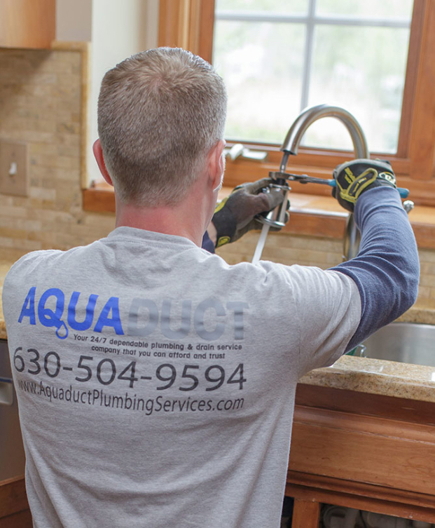 Plumber tightening kitchen faucet